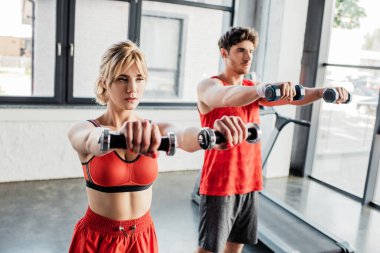 Spor salonundaki halterlerle egzersiz yapan çiftlerin seçici odağı. 