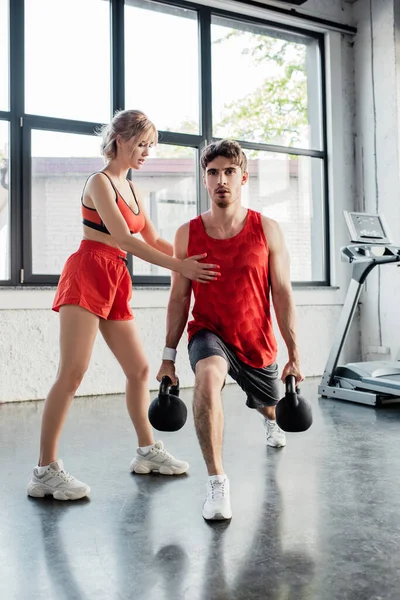 Mulher Esportiva Tocando Homem Bonito Exercitando Com Halteres Pesados Ginásio — Fotografia de Stock