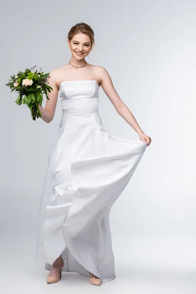 Cheerful Bride Touching Elegant Wedding Dress Holding Flowers White — Stock Photo, Image