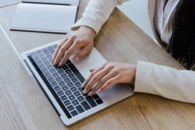 Laptop klavyesinde daktilo eden iş kadınının kırpılmış görünümü 