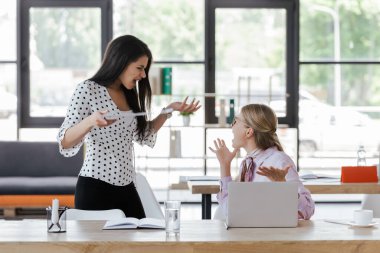 Ofiste el kol hareketi yapan ve tartışan duygusal iş kadınlarının seçici odağı