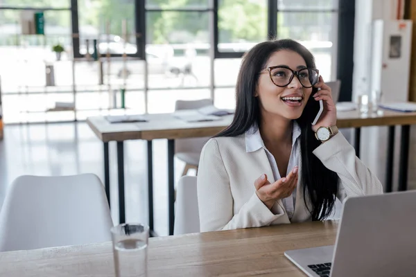 Selektivt Fokus Glada Affärskvinna Glasögon Talar Smartphone Nära Laptop — Stockfoto