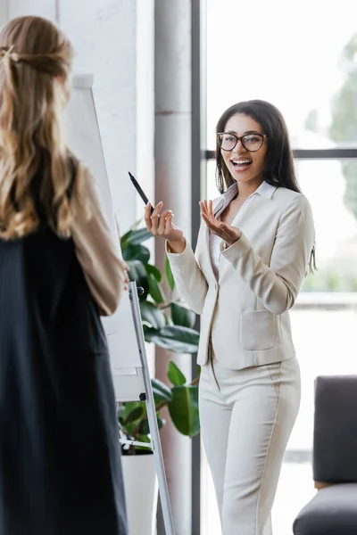 Selective Focus Excited Businesswoman Glasses Gesturing Flipchart Looking Coworker — Stock Photo, Image