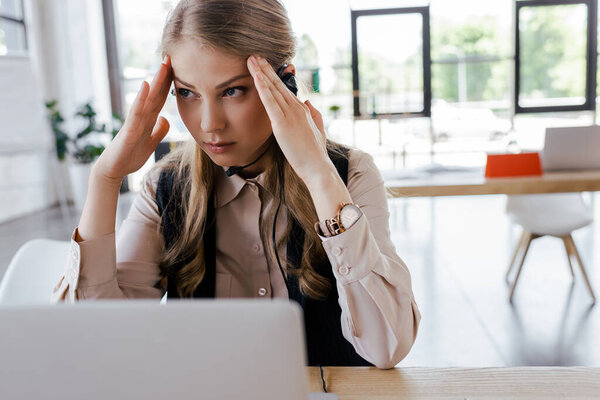 selective focus of tired operator in headset having headache