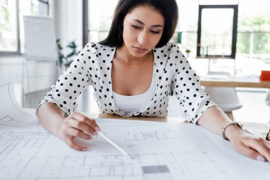 Ofisteki güzel iş kadınının seçici odak noktası planlar çizmesi.