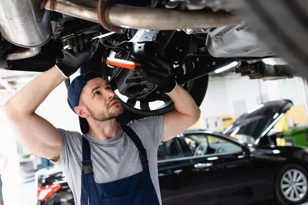 Handsome Mechanic Cap Holding Flashlight Wrench While Repairing Car Service — Stock Photo, Image