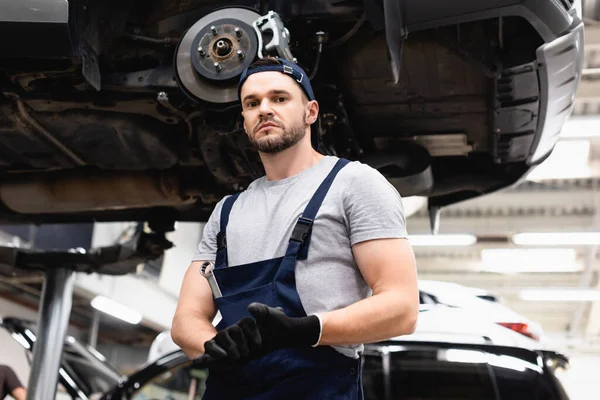 Laag Hoekzicht Van Monteur Rubberen Handschoenen Kijkend Naar Camera Terwijl — Stockfoto