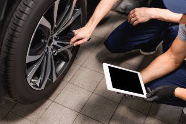 cropped view of mechanic holding digital tablet with blank screen near coworker with wrench repairing car  clipart