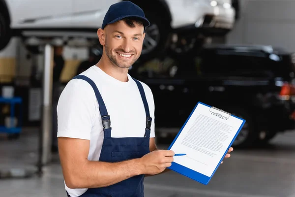 Happy Mechanic Overalls Cap Holding Clipboard Contract Lettering Pen Cars — Stock Photo, Image