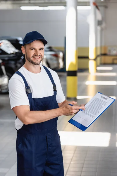 Mecánico Alegre Uniforme Tapa Sujetapapeles Con Letras Contrato Pluma Cerca — Foto de Stock