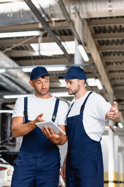 Knappe Monteur Uniform Met Behulp Van Digitale Tablet Gebaren Werkplaats — Stockfoto