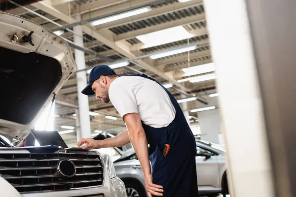 Auto Monteur Leunend Naar Voren Typen Laptop Kap Tankstation — Stockfoto