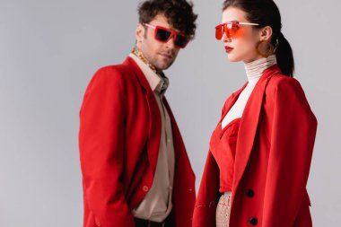 Seçici odak noktası, trend bir adamın kameraya bakması. Gri renkli, şık bir kadın.