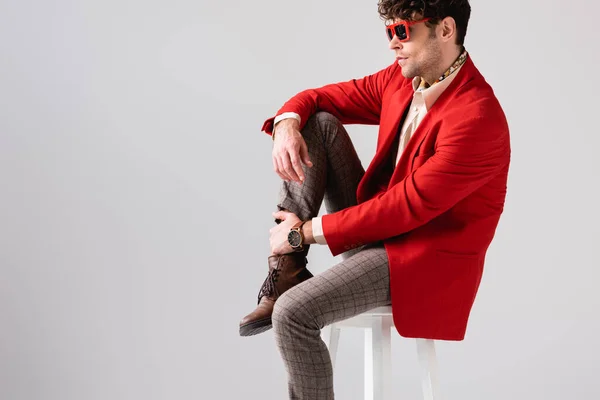 Homem Elegante Blazer Vermelho Óculos Sol Tocando Perna Enquanto Sentado — Fotografia de Stock