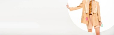Beyaz arka planda, yuvarlak deliğin yanında duran, giysili, fiyat etiketli kız panoramik ürünleri. 