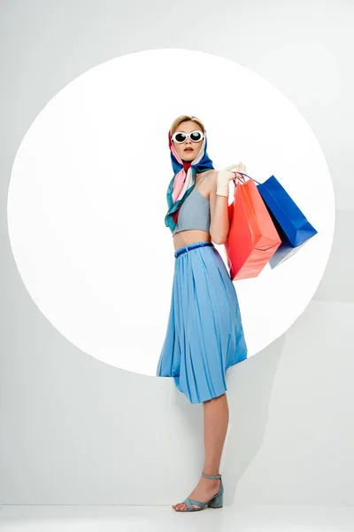 Fashionable Woman Sunglasses Headscarf Holding Blue Red Shopping Bags Circle — Stock Photo, Image