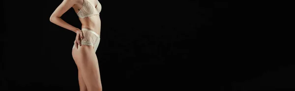 Panoramiczne Uprawy Kobiety Majtki Biustonosz Dotykając Biodra Izolowane Czarno — Zdjęcie stockowe