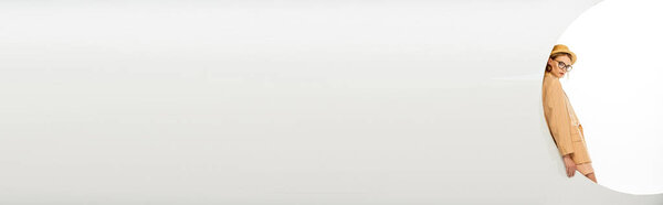 Панорамный снимок стильной женщины, смотрящей на камеру возле круга на белом фоне 