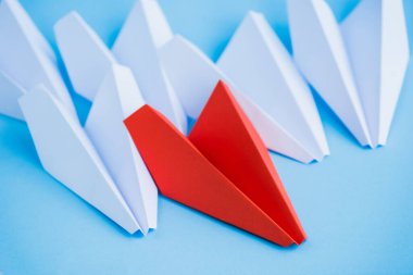 white and red paper planes on blue background, leadership concept  clipart
