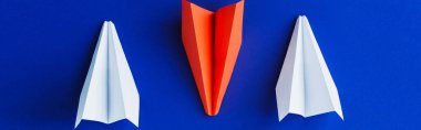 flat lay with white and red paper planes on blue background, leadership concept, panoramic shot clipart