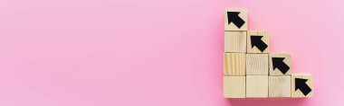 Pembe arka planda siyah okları olan tahta blokların panoramik çekimi, iş konsepti 