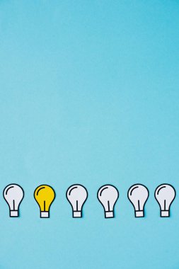 flat lay with paper light bulbs on blue background, business concept clipart