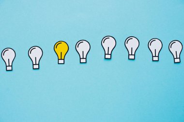 top view of paper light bulbs on blue background, business concept clipart