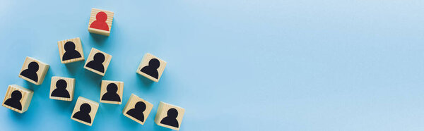 панорамный снимок деревянных блоков с черными и красными человеческими иконами на синем фоне, концепция лидерства