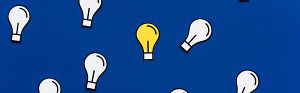 panoramic shot of paper light bulbs on blue background, business concept