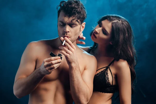 Hombre Guapo Sosteniendo Encendedor Cigarrillo Cerca Mujer Sujetador Sobre Fondo —  Fotos de Stock