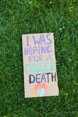 Top view of placard with i was hoping for a cooler death lettering on grass, ecology concept clipart