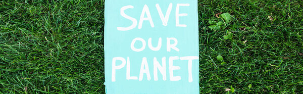 Horizontal concept of placard with save our planet lettering on grass, ecology concept