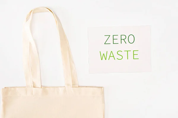 白を基調とした廃棄物ゼロのレタリングでカード近くのバッグのトップビュー 生態学的概念 — ストック写真