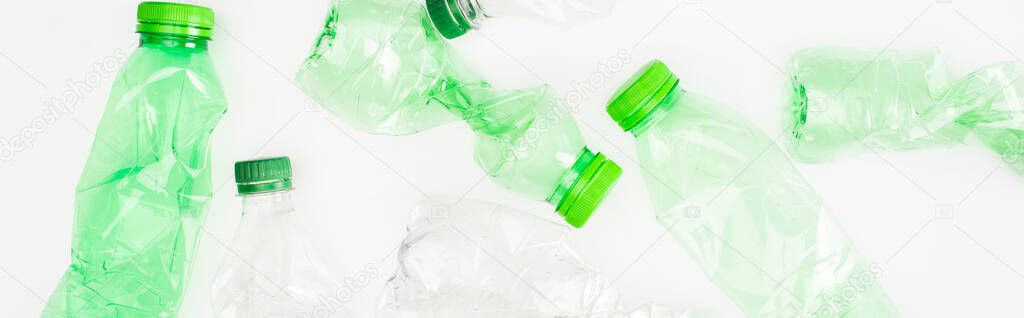 Panoramic orientation of crumpled plastic bottles on white surface, ecology concept