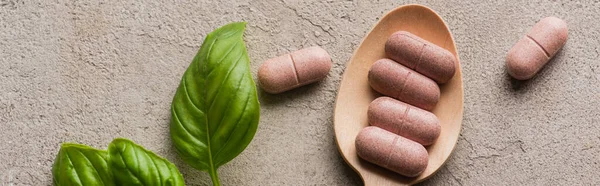 Panoramisch Schot Van Groene Bladeren Pillen Houten Lepel Betonnen Achtergrond — Stockfoto