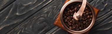 top view of vintage coffee grinder with coffee beans on wooden surface, panoramic shot clipart