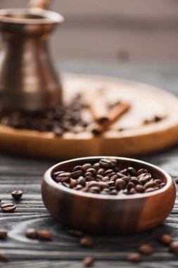 Tahta yüzeyinde kahve çekirdekleri olan kasenin seçici odağı