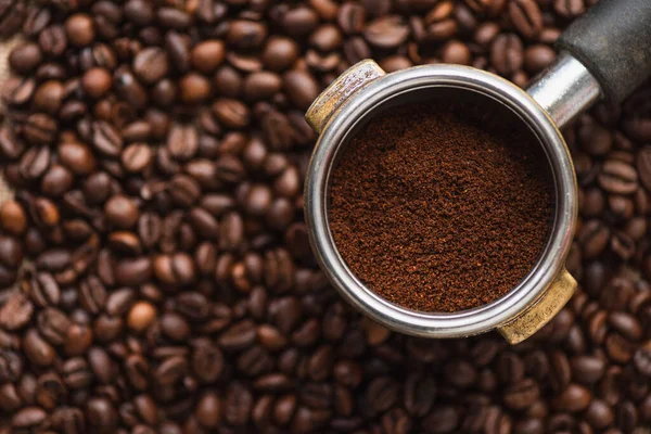 Blick Von Oben Auf Gemahlenen Kaffee Portafilter Auf Kaffeebohnen Hintergrund — Stockfoto