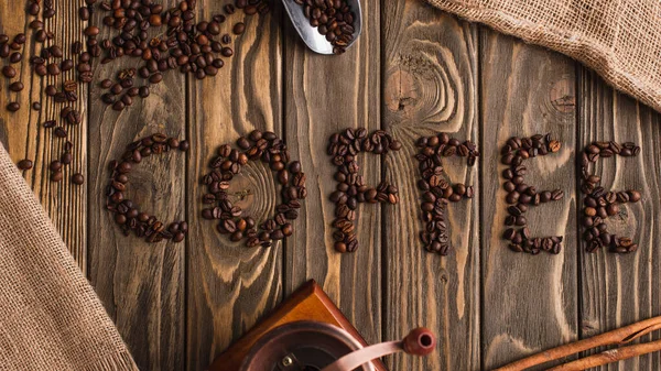 top view of coffee lettering made of beans on wooden surface