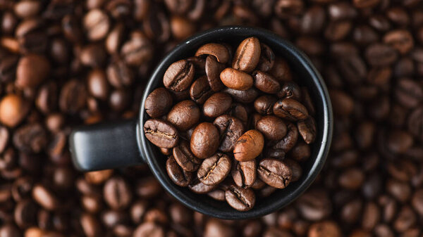 top view of fresh roasted coffee beans in cup