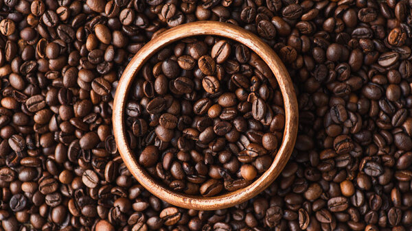 top view of coffee beans in wooden bowl