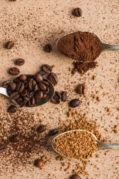 米色表面勺子中的地面 速溶咖啡和豆子的顶部视图 — 图库照片