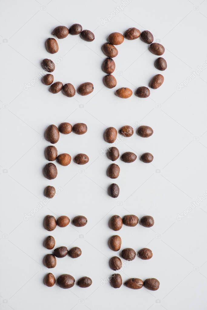 top view of coffee lettering made of beans on white surface