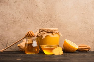 tatlı bal, zencefil kökü ve limon bej beton duvarın yanında ahşap yüzeyde