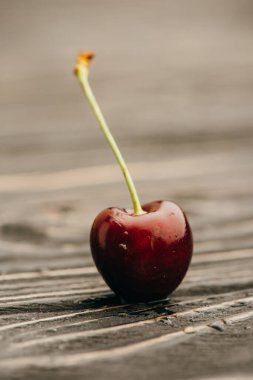 close up view of wet ripe sweet cherry on wooden surface clipart