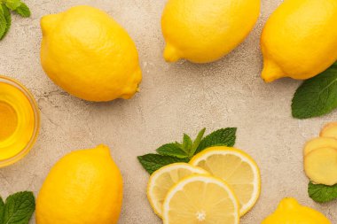 Nane yeşili yapraklı sarı limon ve bej beton yüzeyli bal manzarası
