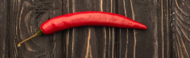 top view of spicy red chili pepper on wooden surface, panoramic shot clipart