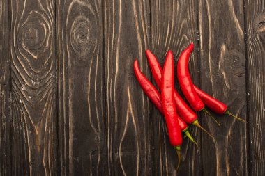 top view of chili peppers on wooden surface clipart