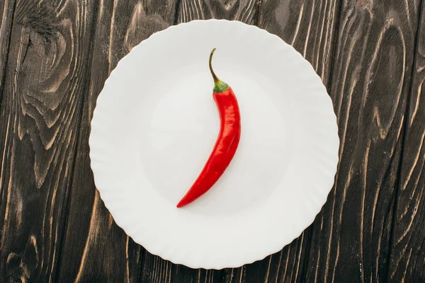 Vrchní Pohled Červený Chilli Pepř Bílém Talíři Dřevěném Povrchu — Stock fotografie