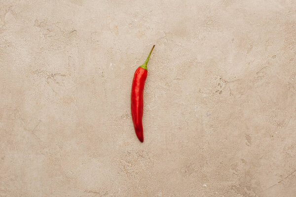top view of red chili pepper on beige concrete surface